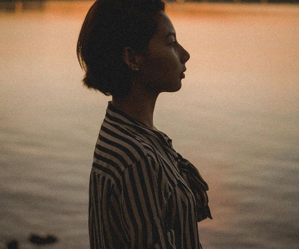 Silhouette of a person stretching against a serene backdrop.